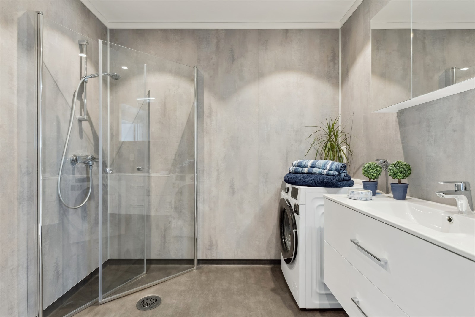 Badet har elektriske varmekabler i gulvet, innfellbare dusjdører og opplegg for vaskemaskin. Galleribilde