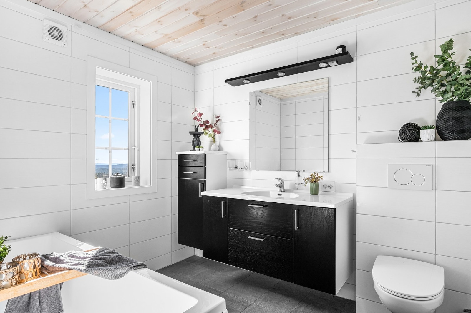 Hovedbadet i første etasje har hvite veggfliser og grå gulvfliser med gulvvarme. Galleribilde