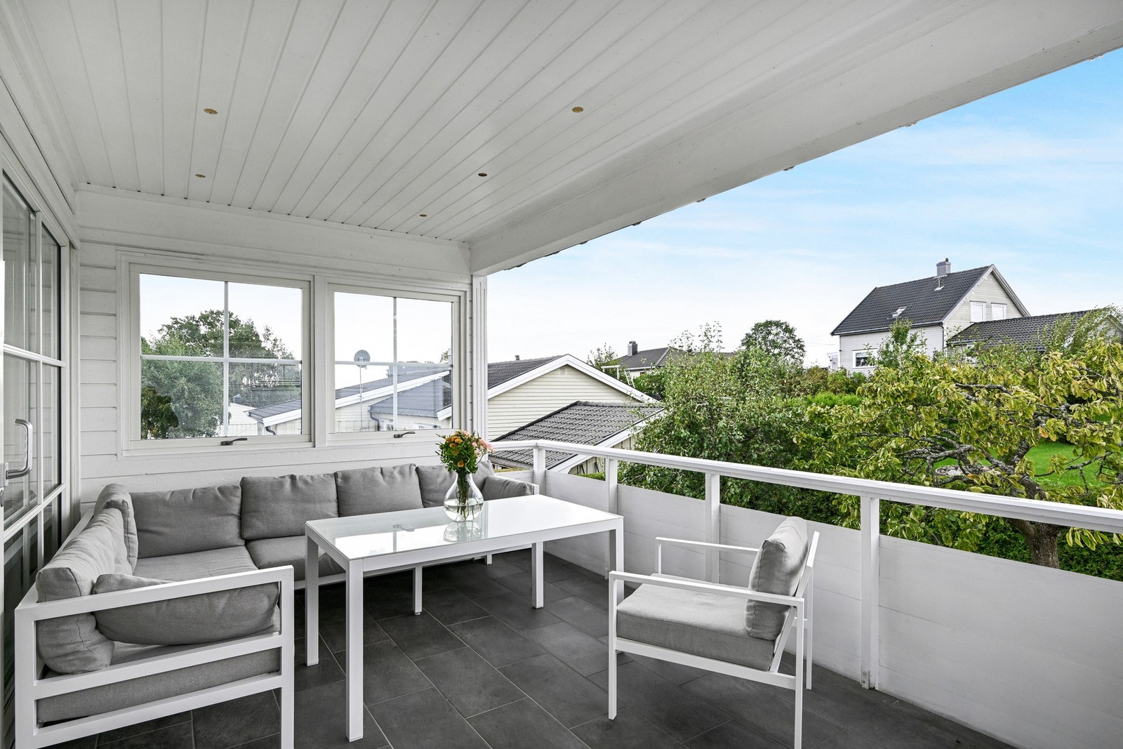 Romslig terrasse med flislagt gulv og levegg mot syd Galleribilde