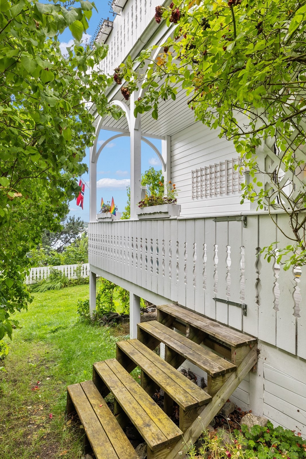 En trapp leder deg ned til den frodige, felles hagen, som er vakkert opparbeidet med blomsterbed, busker og plen - perfekt for rolige stunder, lek eller sosiale sammenkomster. Galleribilde