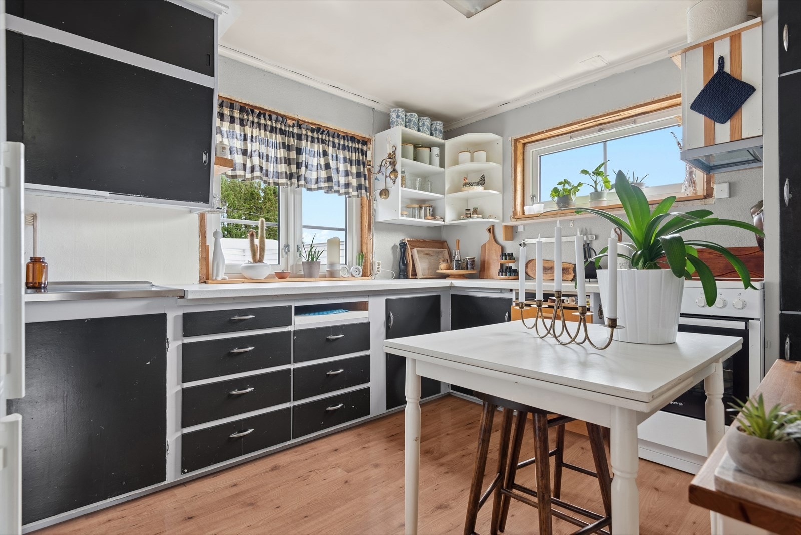 Eldre plassbygget innredning med glatte, mørkmalte fronter.
Benkeplate i laminat. Løse hvitevarer. Komfyr medfølger. Galleribilde