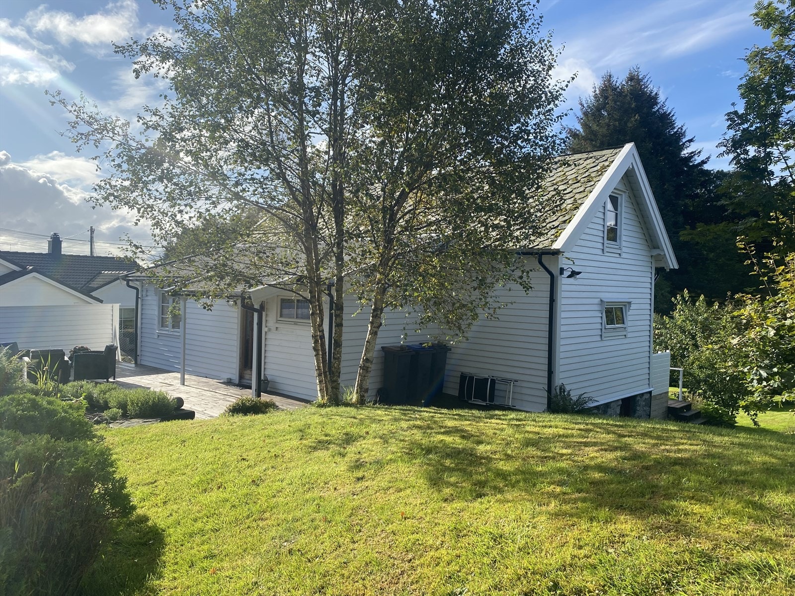 Solrik beliggenhet med uteplasser langs husets langsider Galleribilde