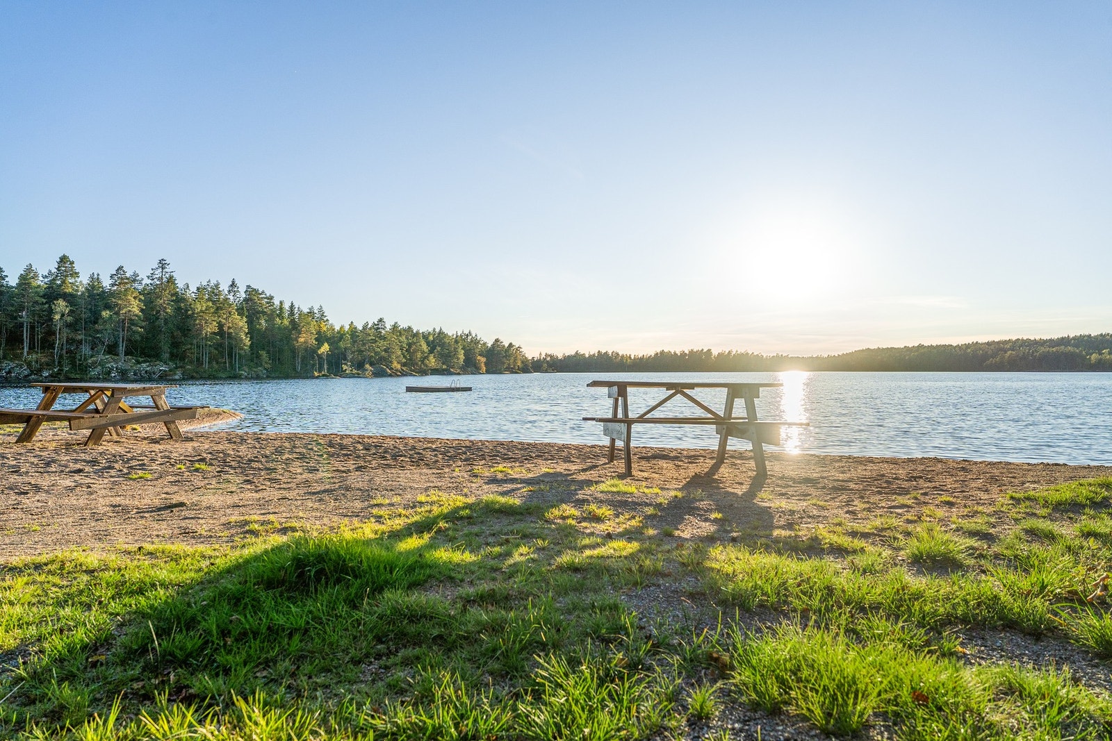 Flott badestrand med sittemuligheter og flytebrygge. Galleribilde