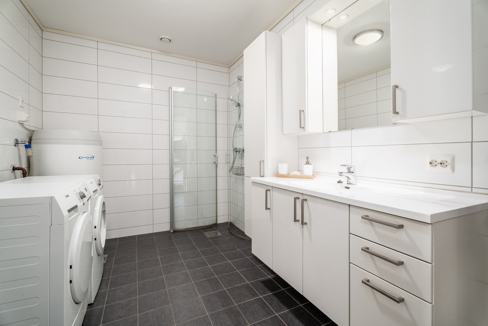 Flislagt bad med romslig baderomsinnredning. Galleribilde