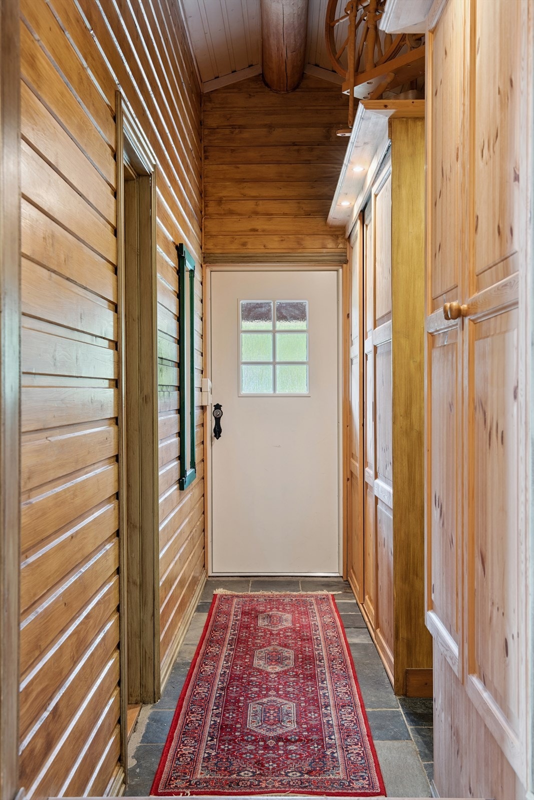 Entreen har flislagt gulv og er innredet med flere garderobeskap langs den ene veggen. Galleribilde