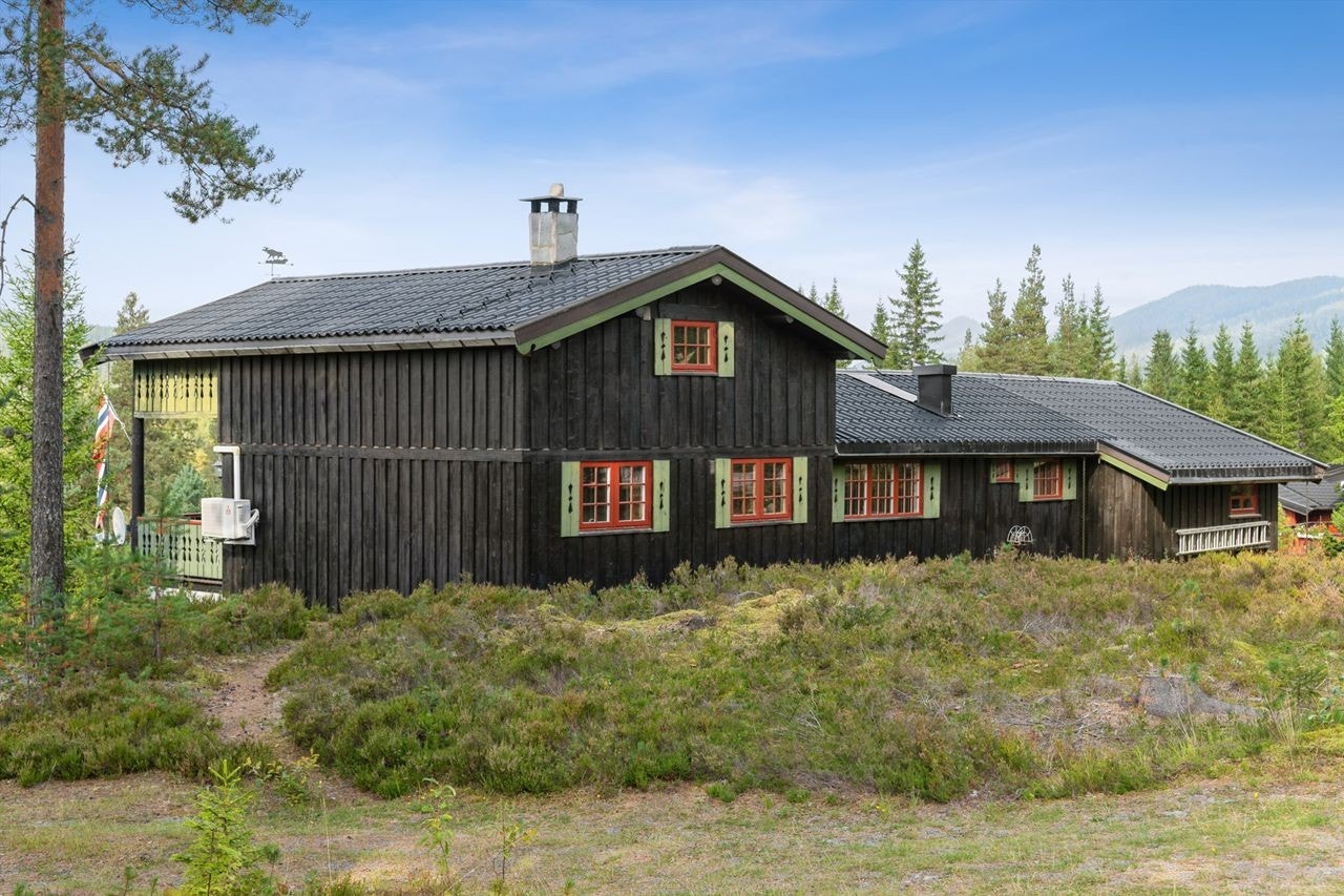 En tradisjonsrik fritidsbolig med stående kledning, oppført i 1976 med tilbygg fra 2003. Galleribilde