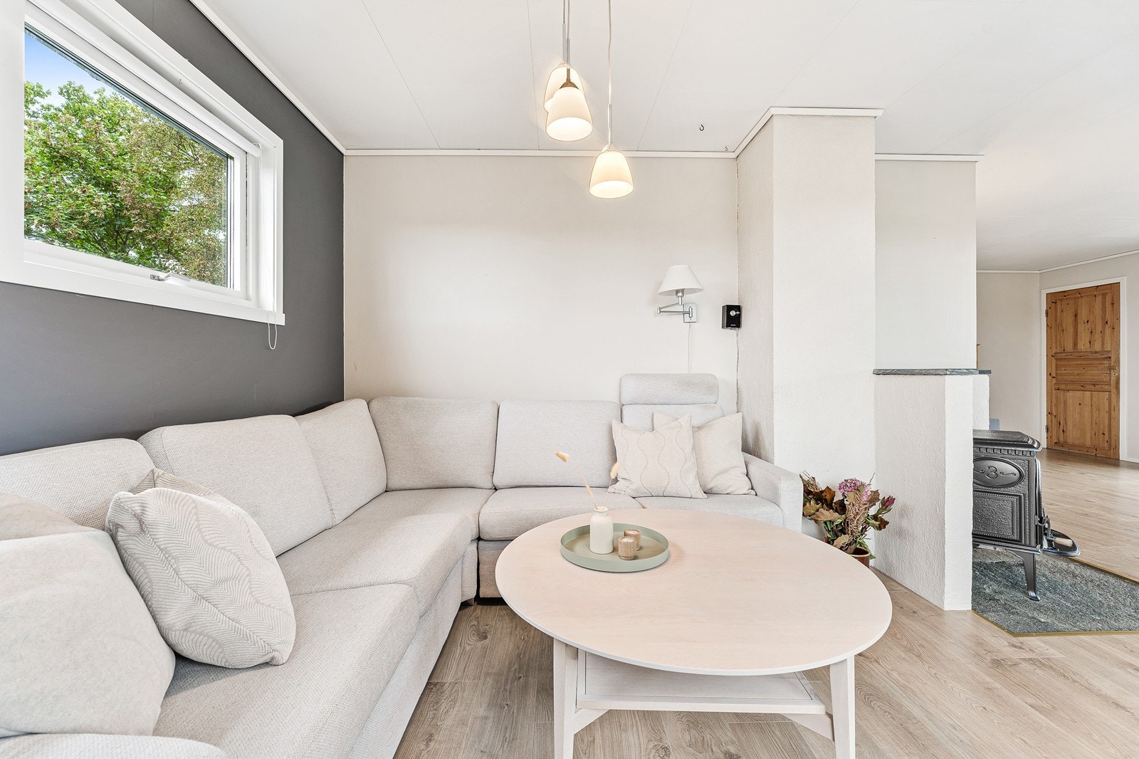 Midt i rommet står en klassisk vedovn som skaper både varme og stemning på kalde høst- og vinterdager. Galleribilde