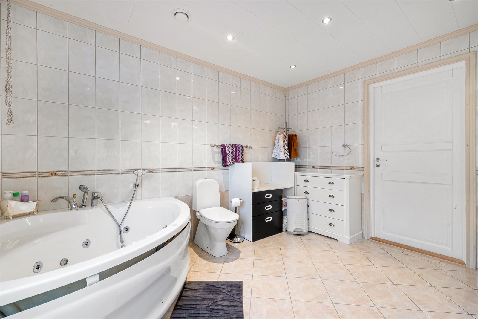 Rommet er innredet med baderomsinnredning, gulvmontert toalett og badekar Galleribilde