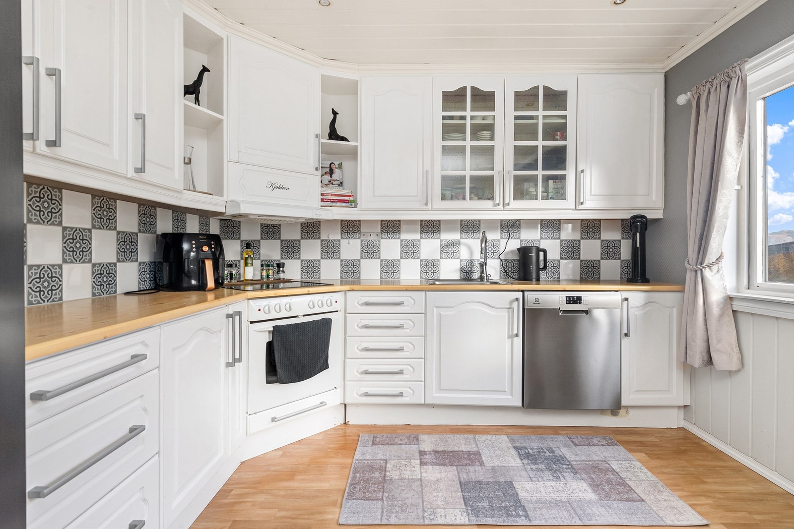 Kjøkkeninnredning med underskap og takhøye overskap, malte profilerte fronter Galleribilde