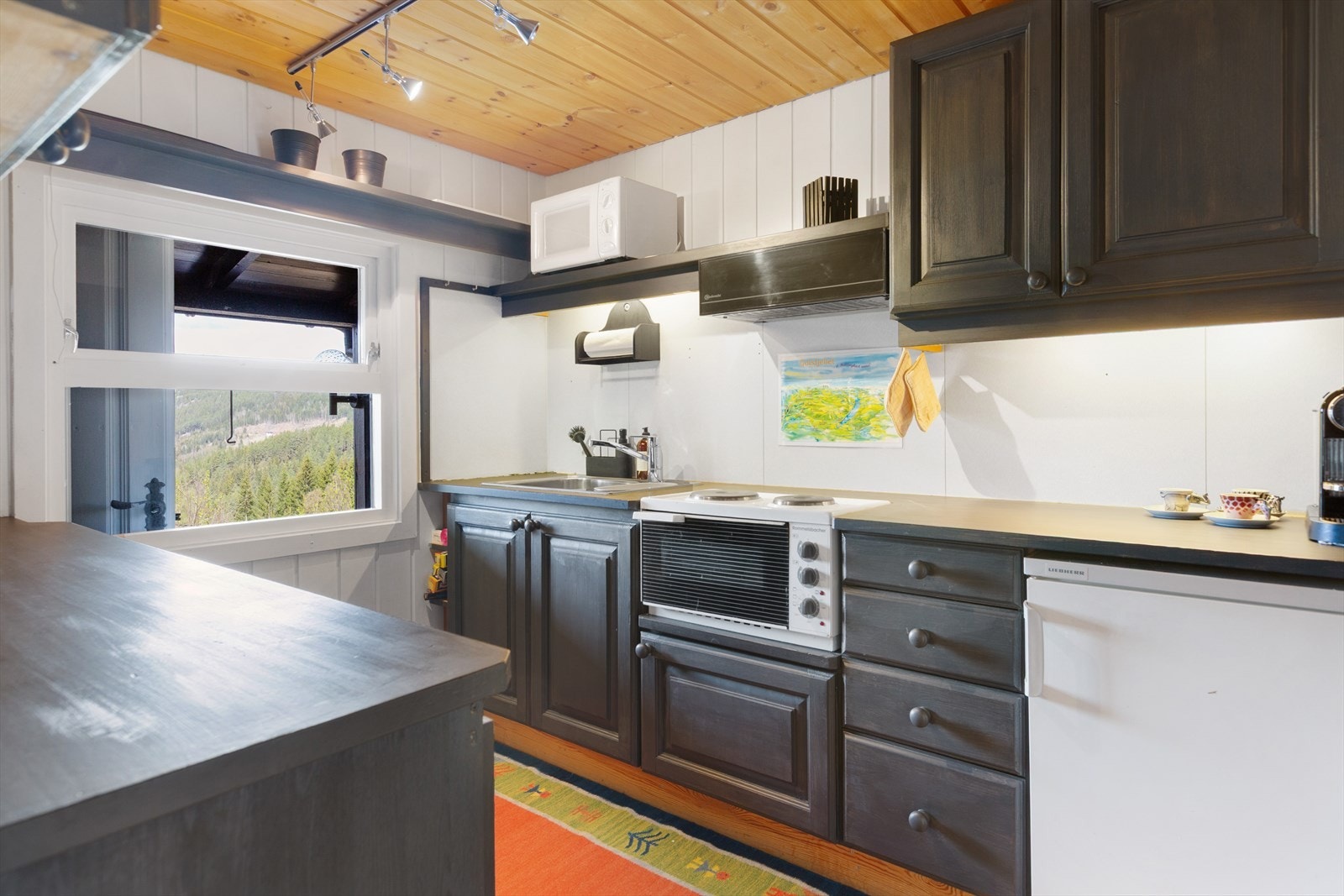 Kjøkkenet har godt med benkeplass, over- og underskap. Galleribilde