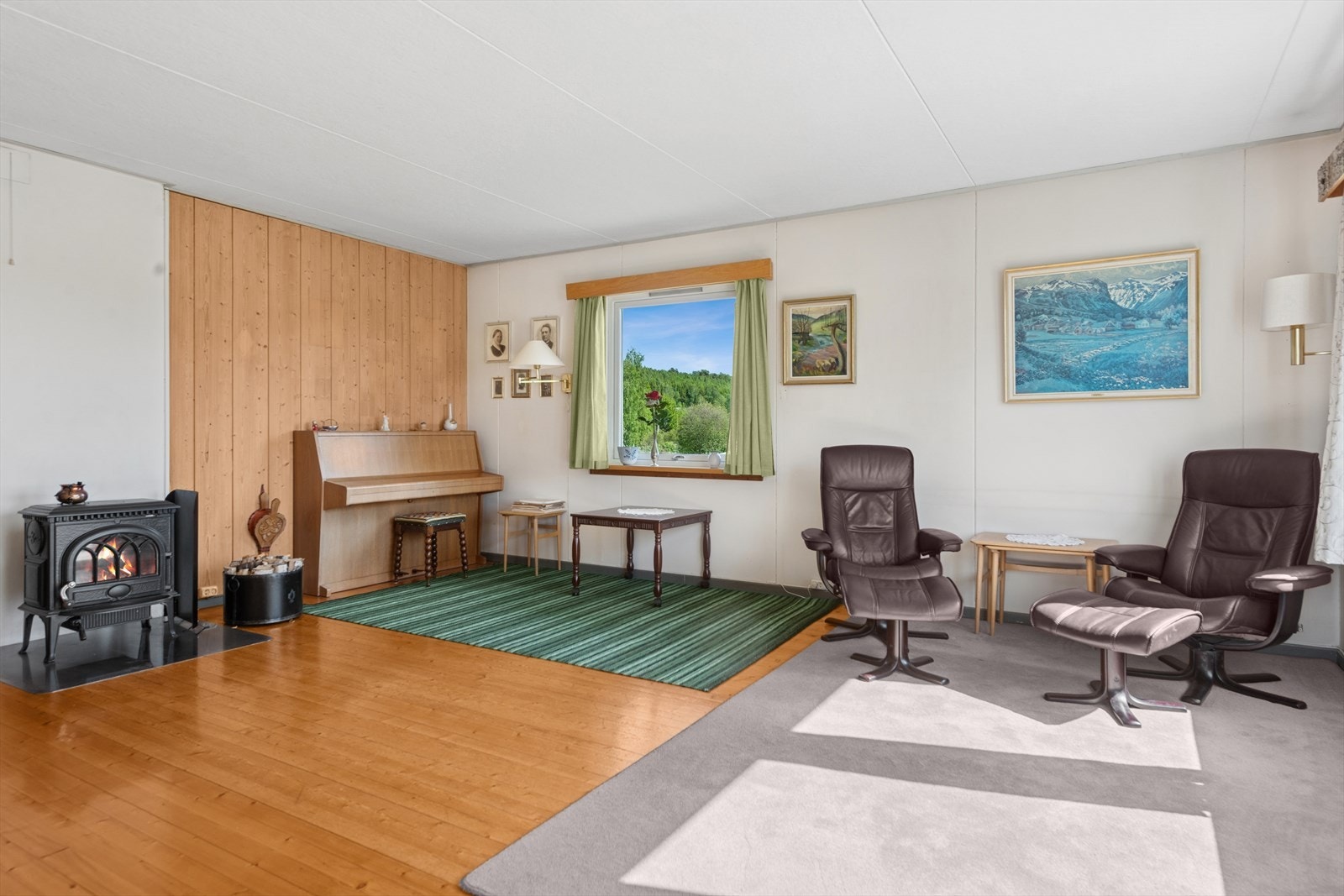 Stuen er romslig og byr på god plass til sosiale soner, med plass til sofagruppe med TV-løsning, godstol og et spisebord mot kjøkkenet. Galleribilde