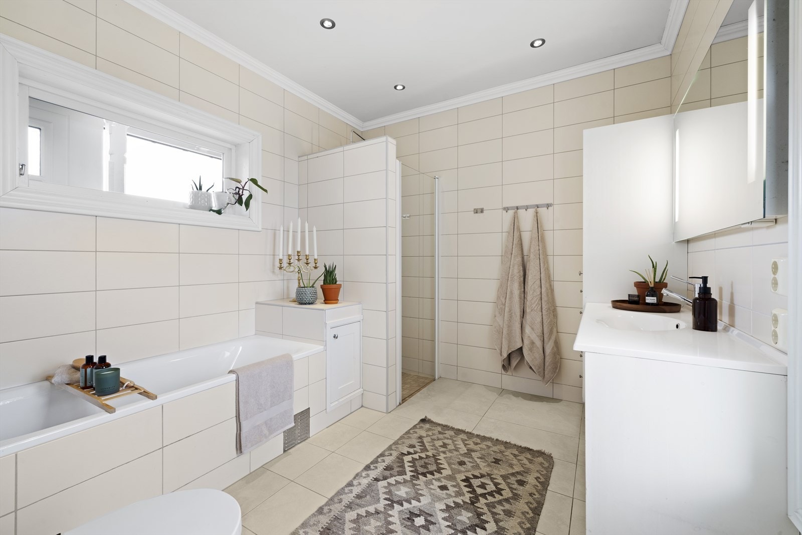 Hovedbad med nøytrale fliser på vegg og gulv, med varmekabler Galleribilde