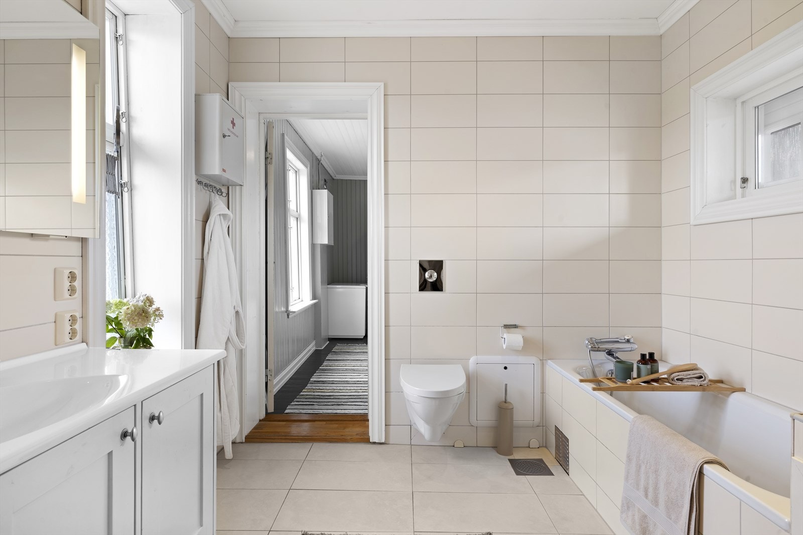 Baderommet har innfliset badekar, dusjnisje med glassdør og vegghengt toalett Galleribilde