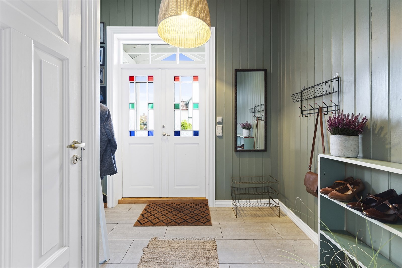 Fra overbygget inngangsparti kommer man inn til flislagt entrè som gir et godt førsteinntrykk av boligen Galleribilde