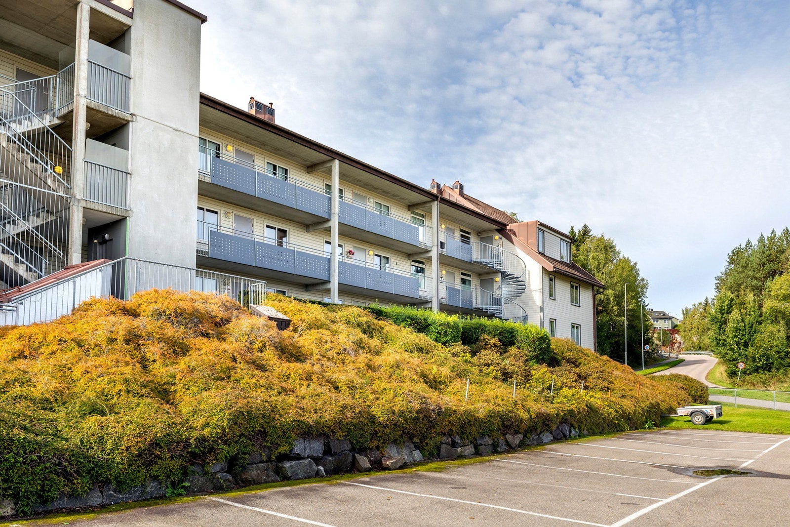 Sameiets tomt er pent opparbeidet med bl.a. plen, busker, asfalt og parkeringsplasser. Galleribilde