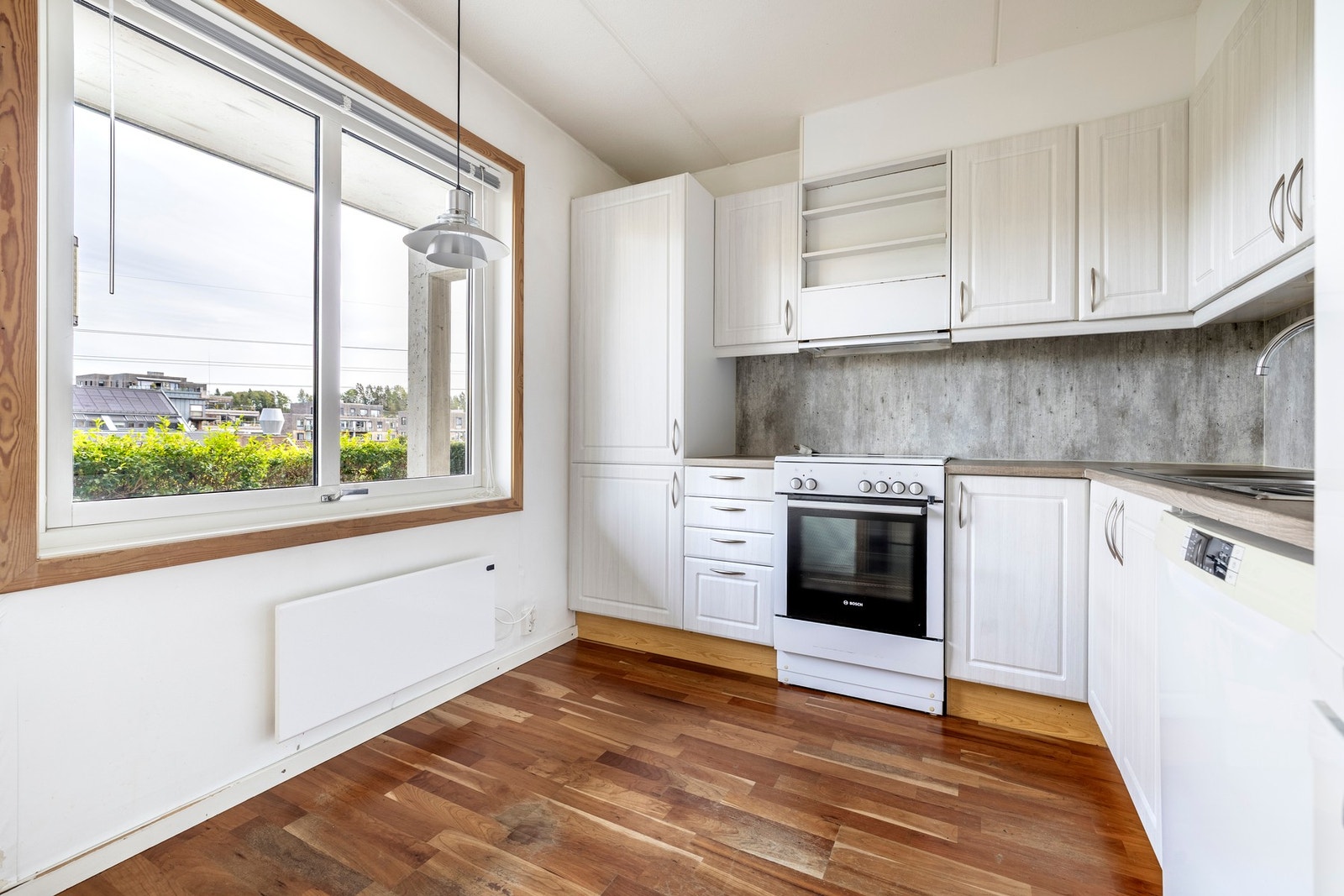 Kjøkkeninnredningen har folierte fronter i profiler utførelse og laminerte benkeplater med nedfelt oppvaskkum med avrenningsplate. Galleribilde