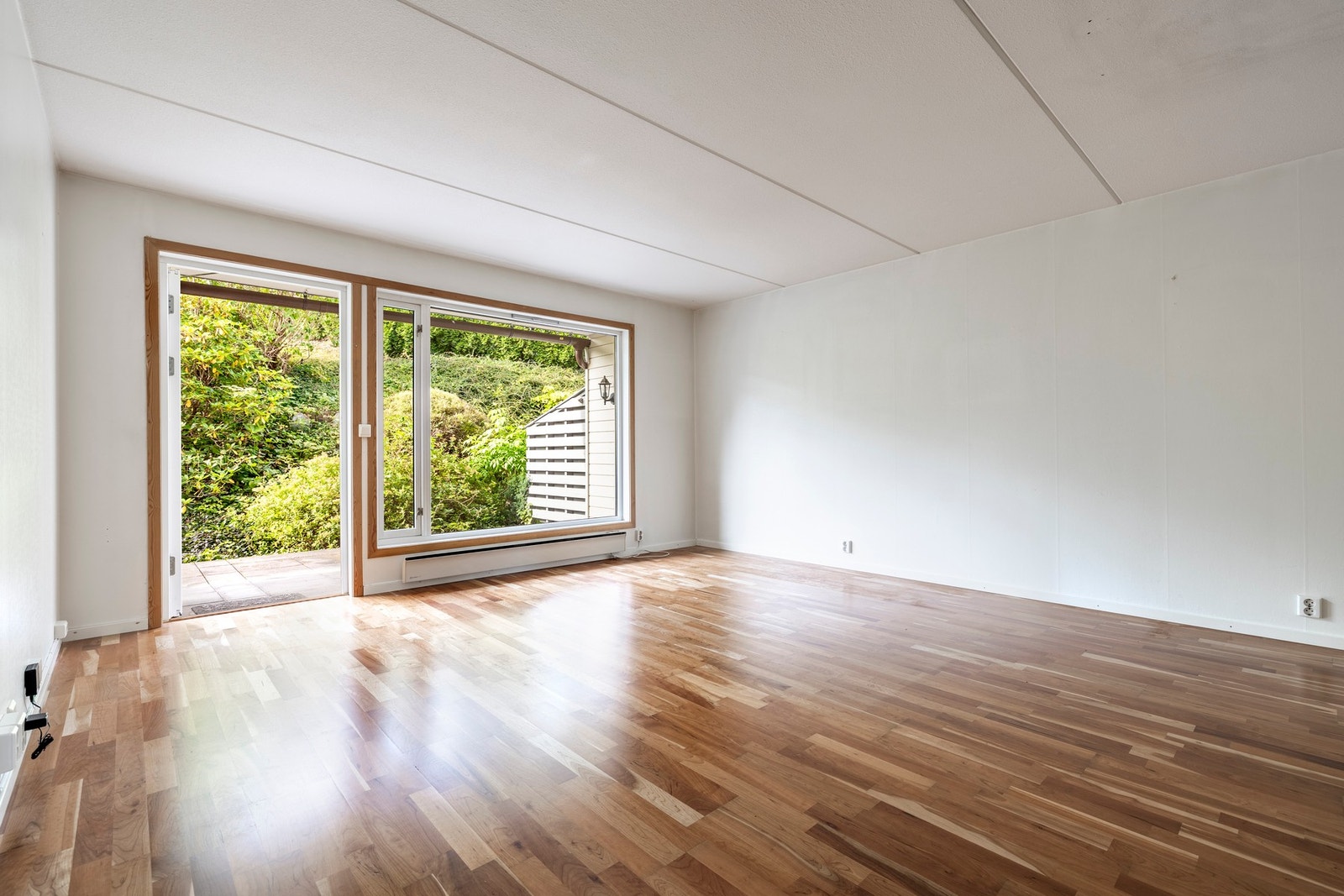 Stuen er lys og romlig med lysmalte vegger og trestavs parkett. Galleribilde