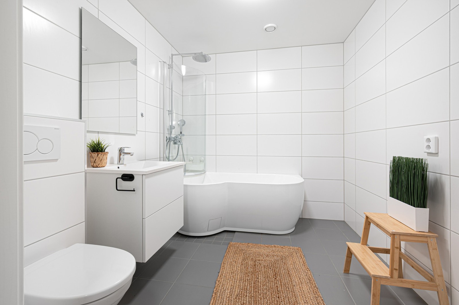 Lekkert bad i kjelleretasjen med dusjløsning, badekar, toalett og moderne innredning. Galleribilde