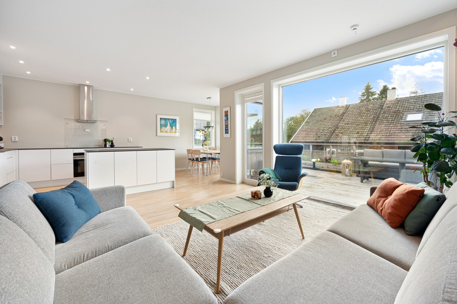 Moderne stue med stilrene overflater og store vinduer som slipper inn mye dagslys. Galleribilde