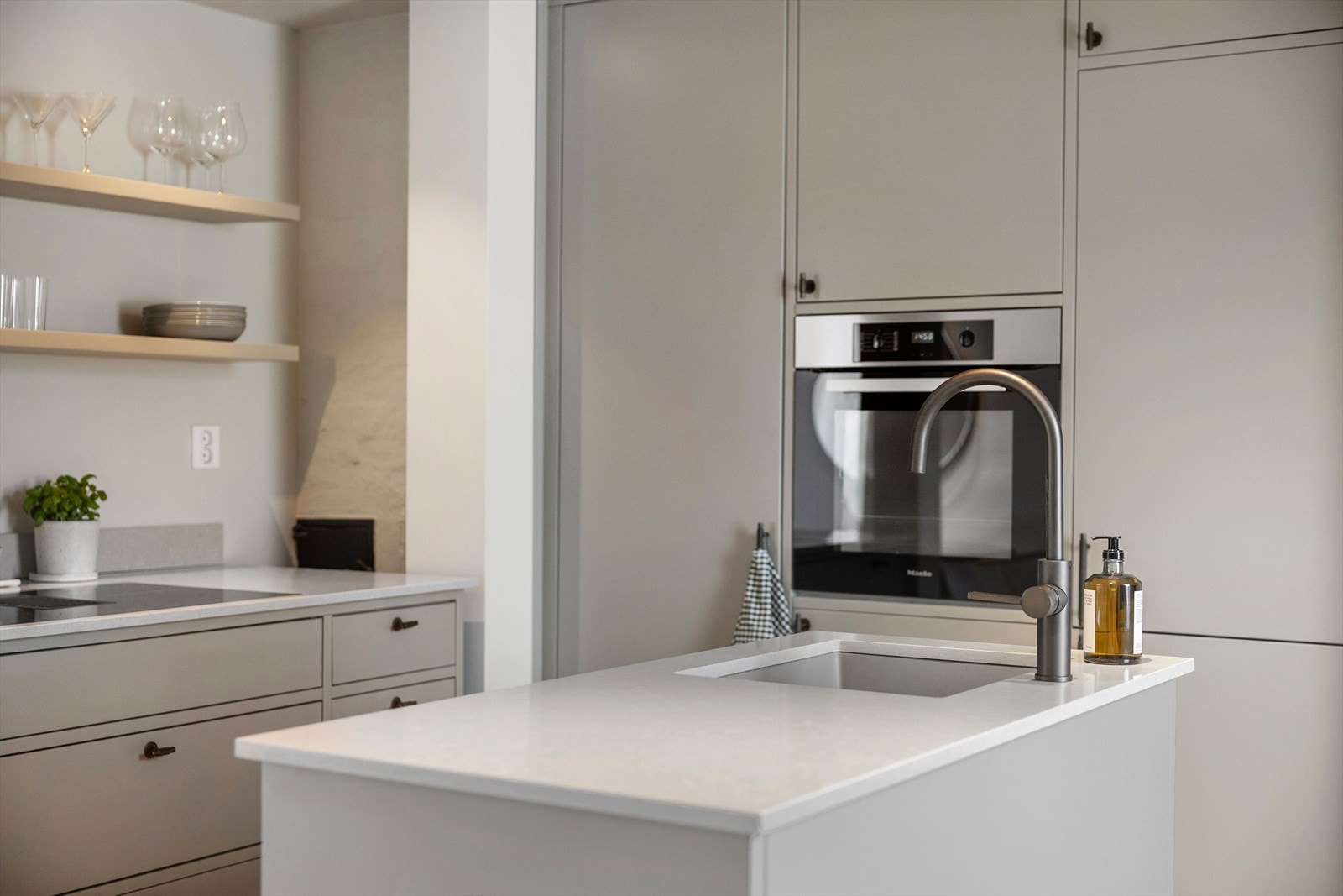 Kjøkkenet har glatte fronter og benkeplate i stein med nedfelt oppvaskkum og ettgreps svingbart blandebatteri fra Tapwell. Galleribilde