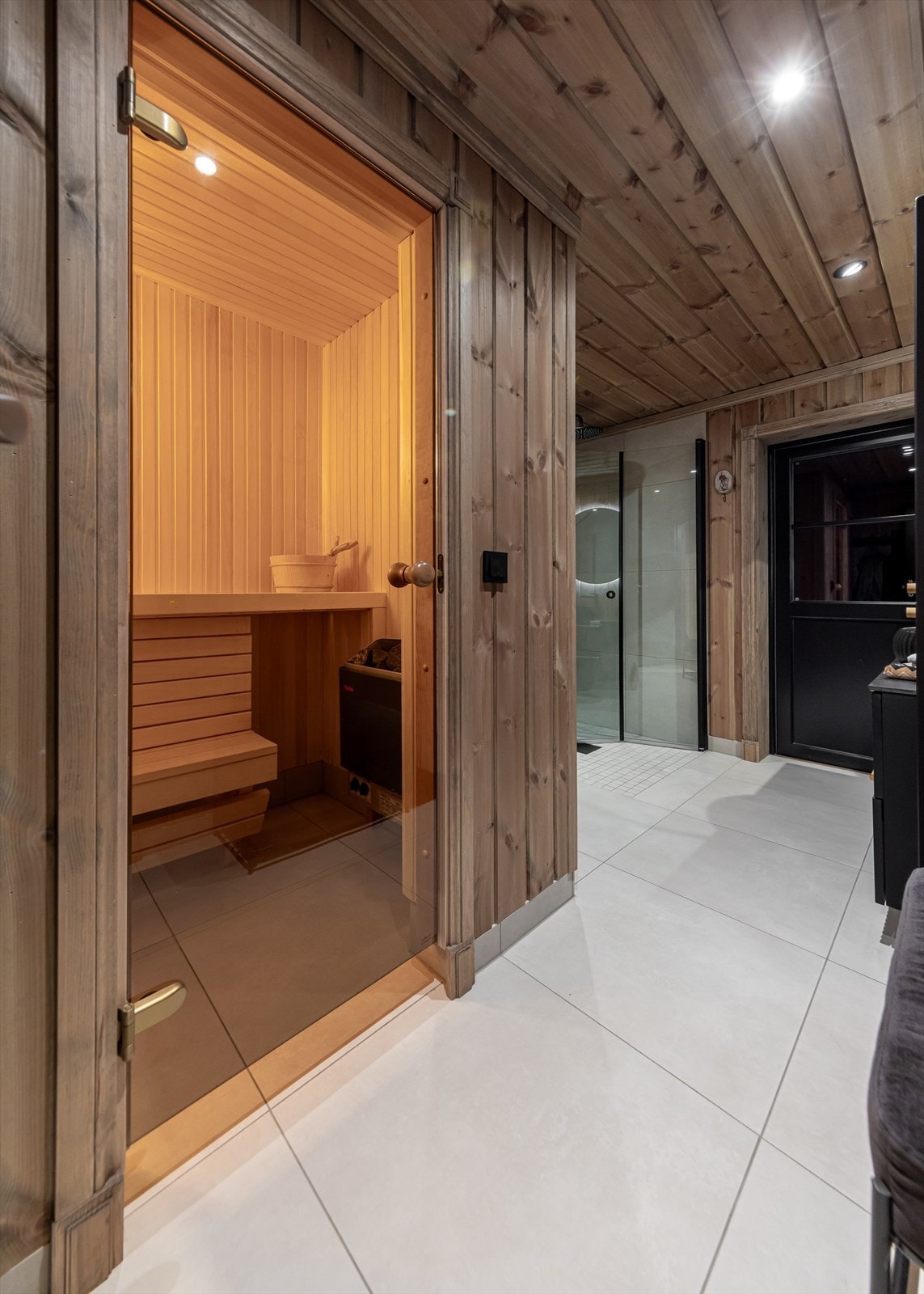 Baderommet er utstyrt med dusjhjørne, innfellbare dusjdører, veggmontert wc, servant, servantskap og mekanisk avtrekk, samt badstue Galleribilde