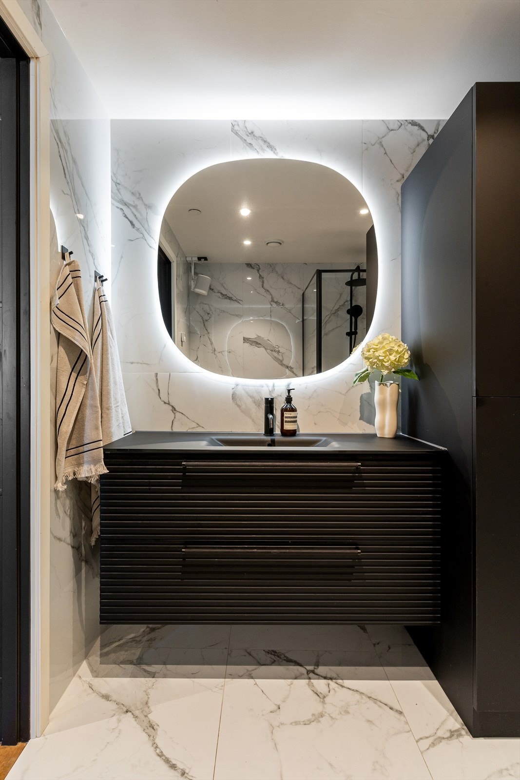 Badet er innredet med vegghengt toalett, servant nedfelt i innredning og dusjhjørne med svingbare glassdører, og har balansert ventilasjon. Galleribilde