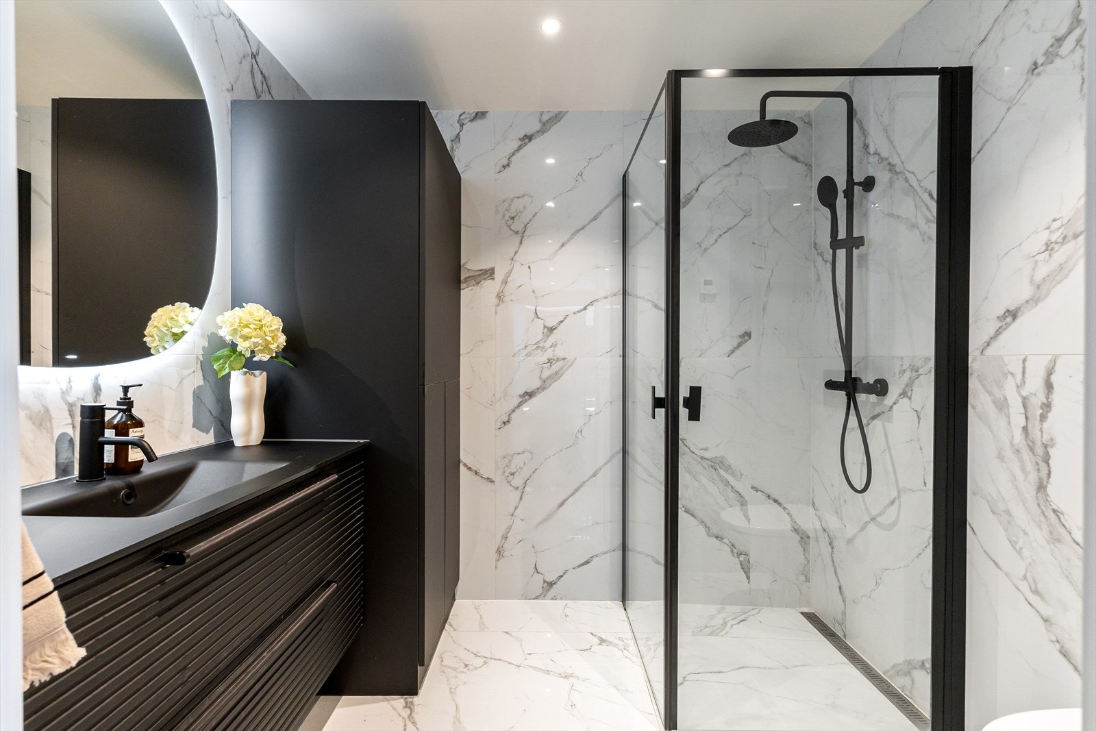 Delikat flislagt baderom med gulvvarme og downlights i himlingen, pusset opp i 2022. Moderne og stilrent med gjennomført finish. Galleribilde