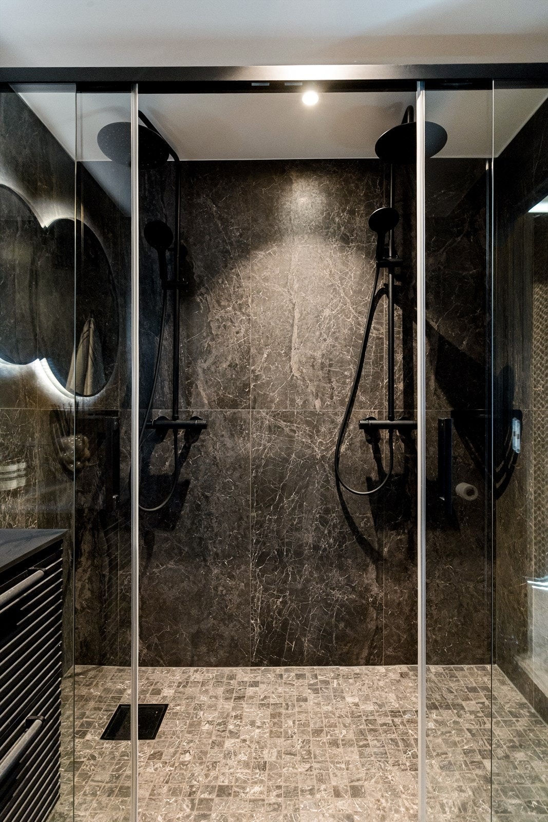 Badet er innredet med vegghengt toalett, dobbel servant i innredning og dobbel dusj i nisje, med balansert ventilasjon. Galleribilde