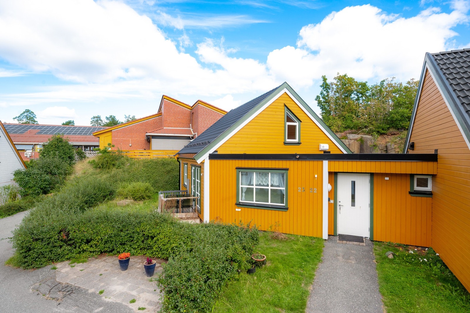 Inngangssiden med malt hovedytterdør (2024), TG1. Pent opparbeidet adkomst og lavt vedlikeholdsbehov etter oppgraderinger i 2024. Galleribilde