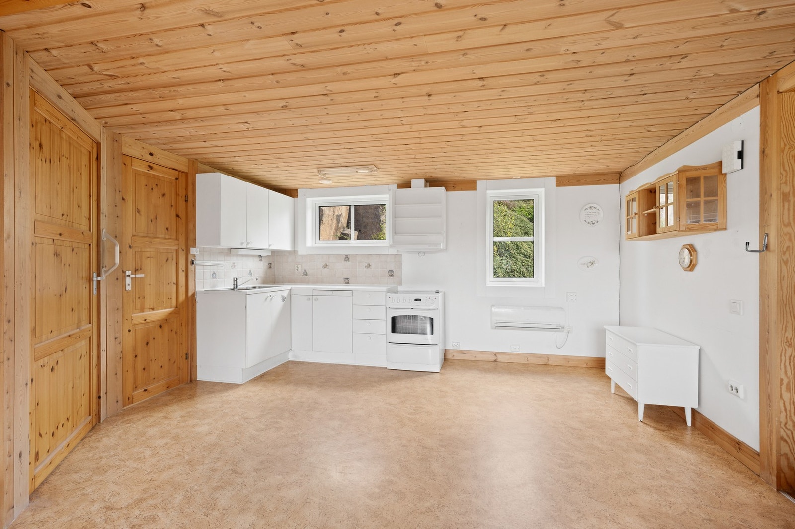 Kjøkken med glatte fronter, laminat benkeplate, komfyr og vannstoppsystem. Ventilator med avtrekk ut. Galleribilde