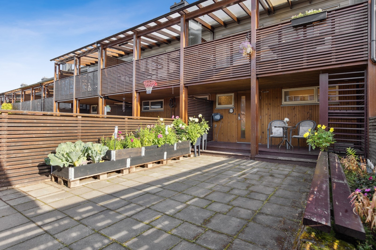 Inngangspartiet er pent opparbeidet med steinbelagt gårdsplass og hagedekor. Galleribilde