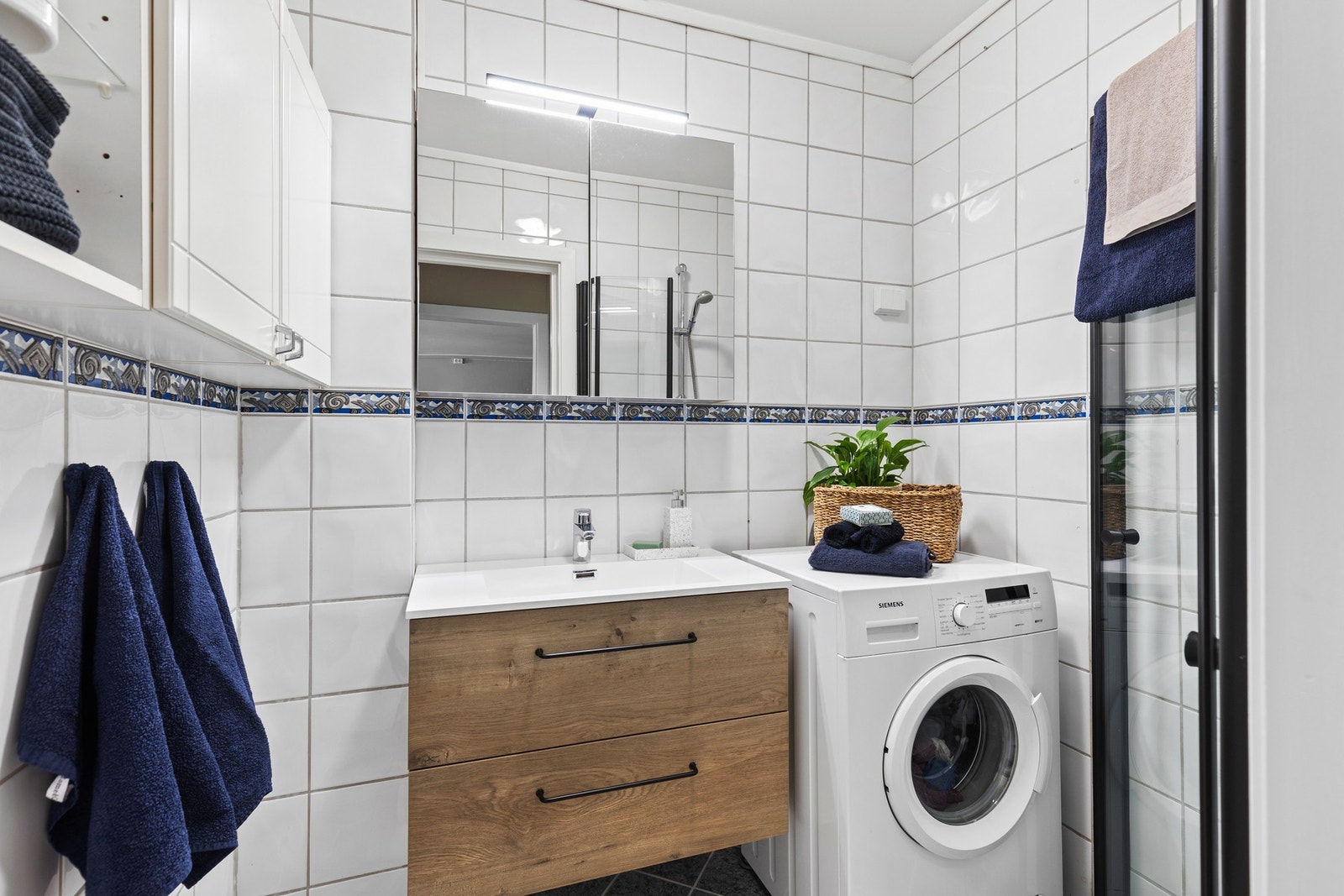 Lyst, flislagt bad med varmekabler i gulvet. Innfellbare dusjdører frigjør mye plass på badet. Galleribilde