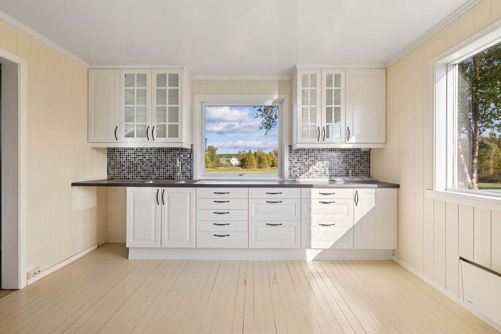 Kjøkkenet er innredet slik at matlagingen forenes med sosialt samvær. Det generøse vinduet slipper inn mye naturlig lys. Galleribilde