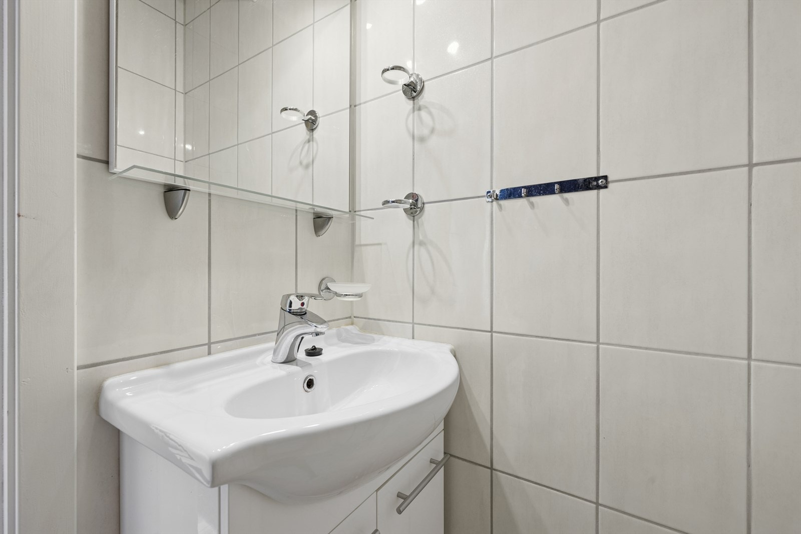 Lys baderomsinnredning med underskap, servant og speil. Galleribilde