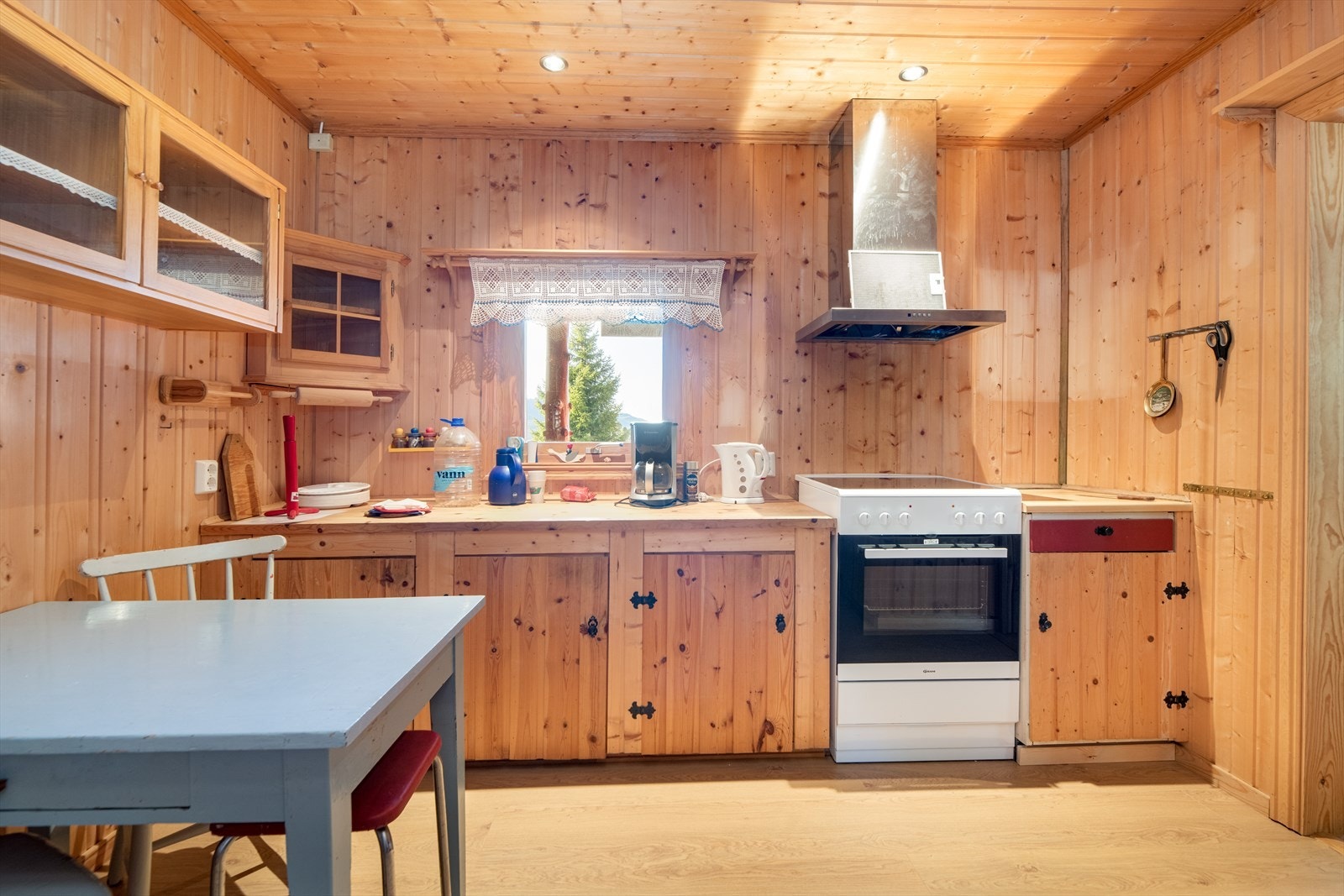 Laminert benkeplate med gode arbeidsflater. Over kokesonen er det ventilator med avtrekk ut. Galleribilde