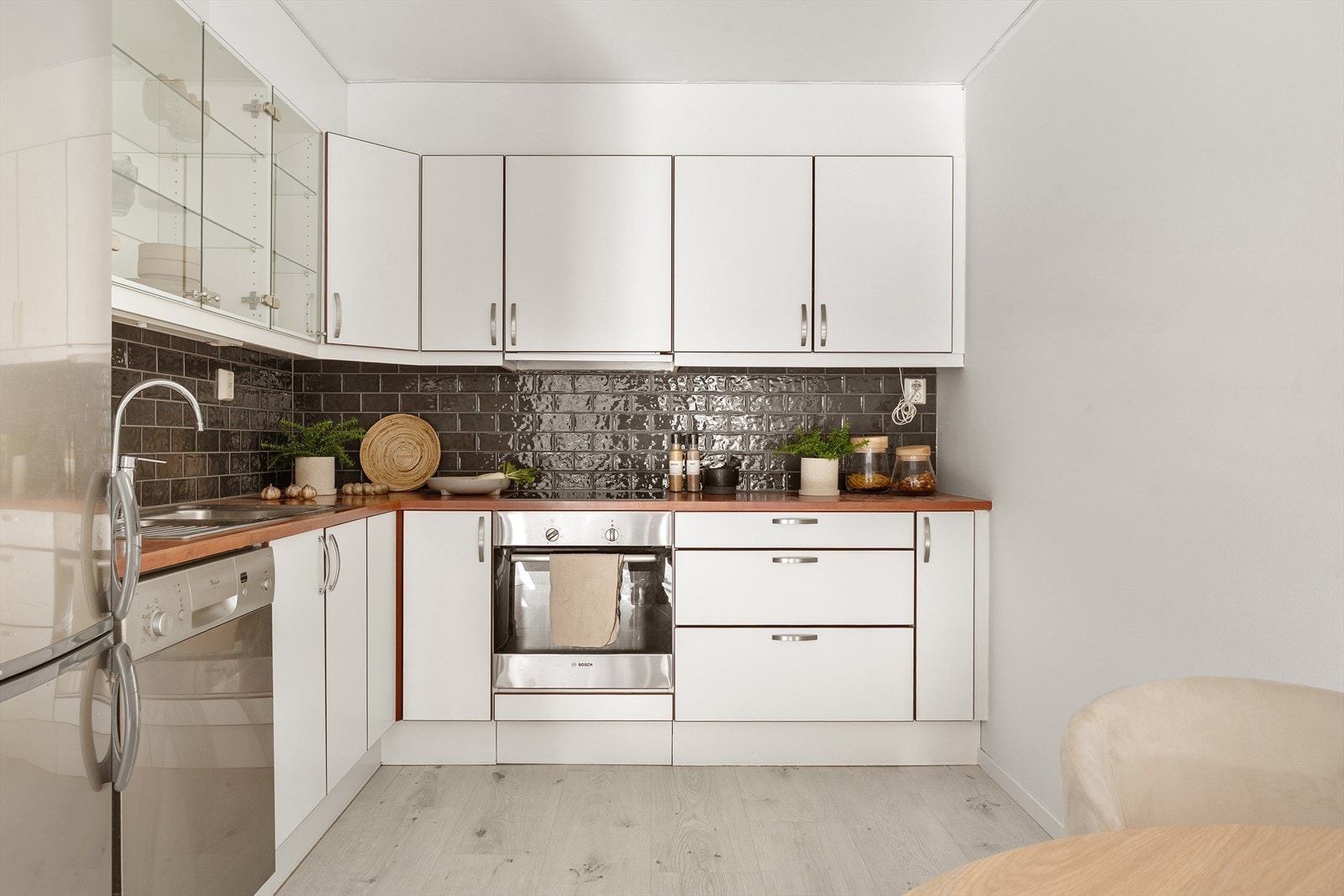 Kjøkkenet er innredet med lyse fronter og laminat benkeplate. Fliser over kjøkkenbenken. Galleribilde