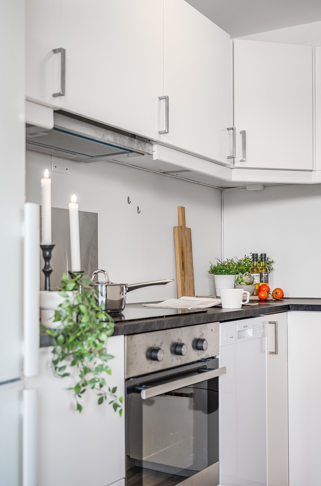 Innredningen har hvite glatte fronter og laminert benkeplate med nedfelt oppvaskkum. Praktisk med metallplater i benkeryggen ved platetoppen og oppvaskkummen. Galleribilde