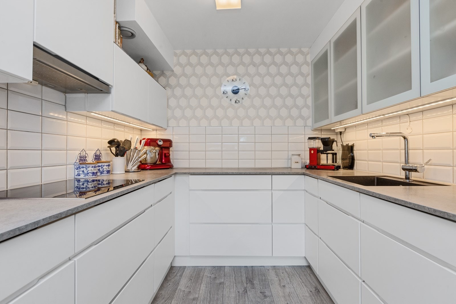 Stilrent og funksjonelt kjøkken fra 2018 med god skap- og benkeplass. Hvite fronter, integrerte hvitevarer og moderne belysning gir et tidsriktig preg Galleribilde