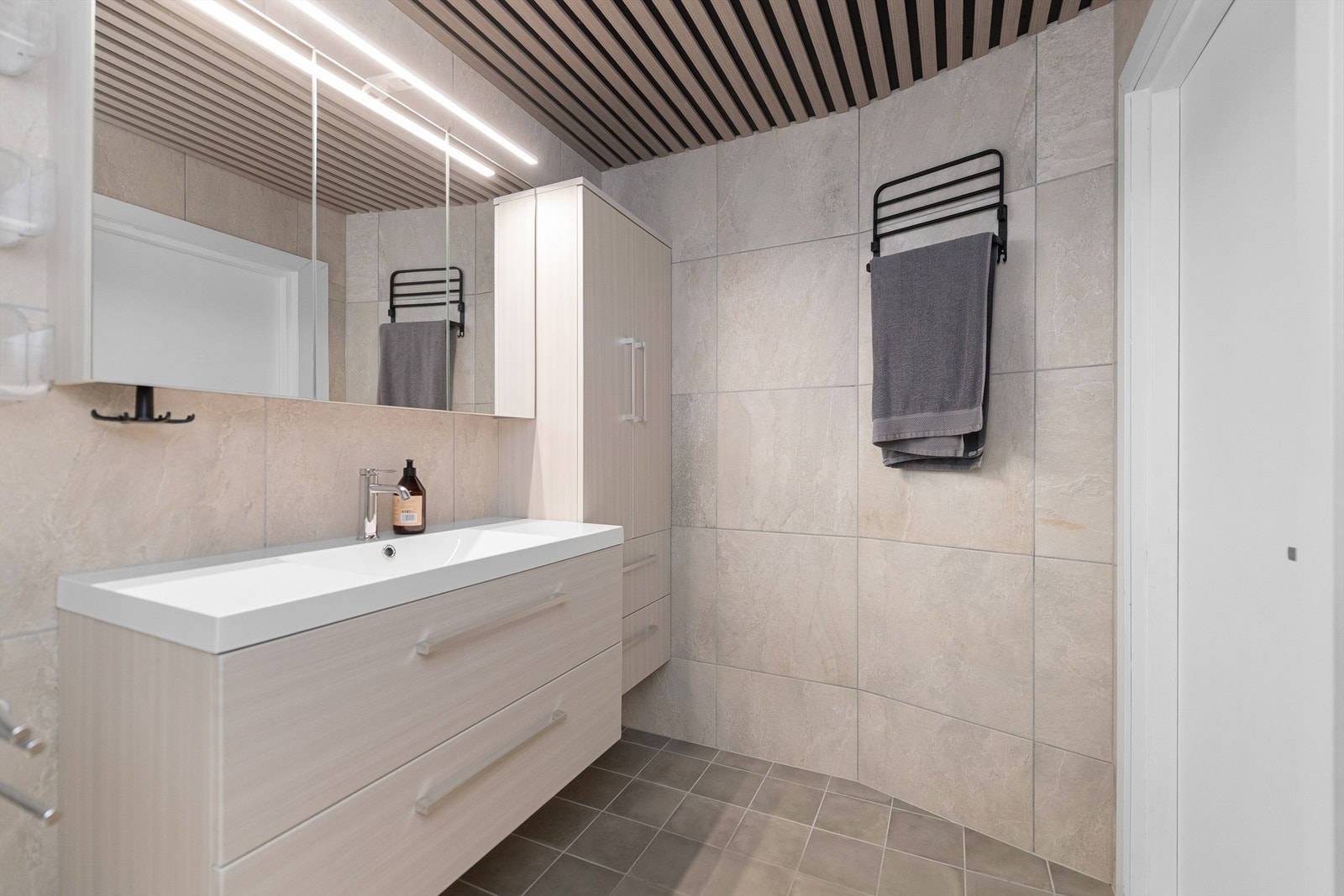 Badet er utstyrt med baderomsinnredning og badekar Galleribilde