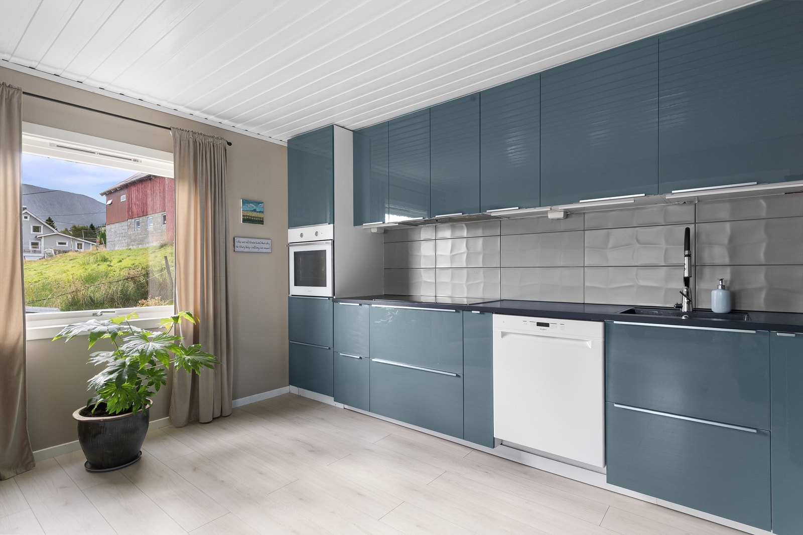 Innredning med underskap og takhøye overskap. Både integrerte og frittstående hvitevarer. Galleribilde