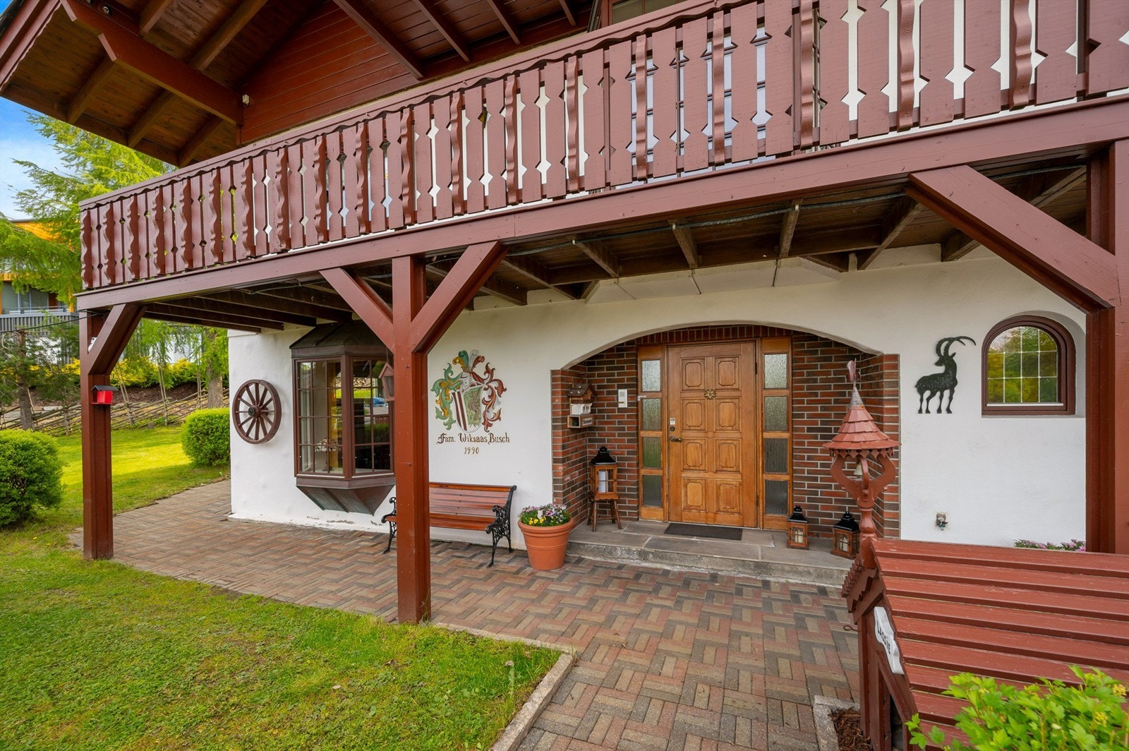 Flott, herskapelig inngangsparti med selvlaget familievåpen på veggen. Galleribilde