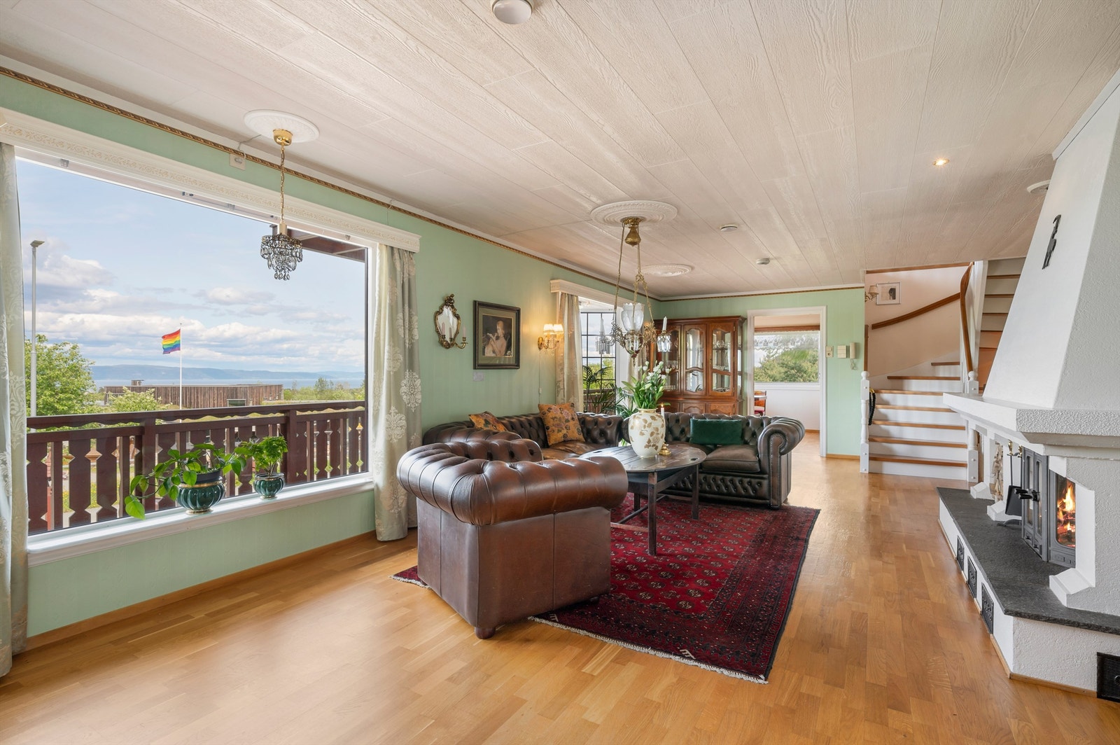 Stua er et stort og vakkert rom på hele 53 kvm, med et blikkfang en peis på den ene siden og fjordutsikten på den andre. Galleribilde