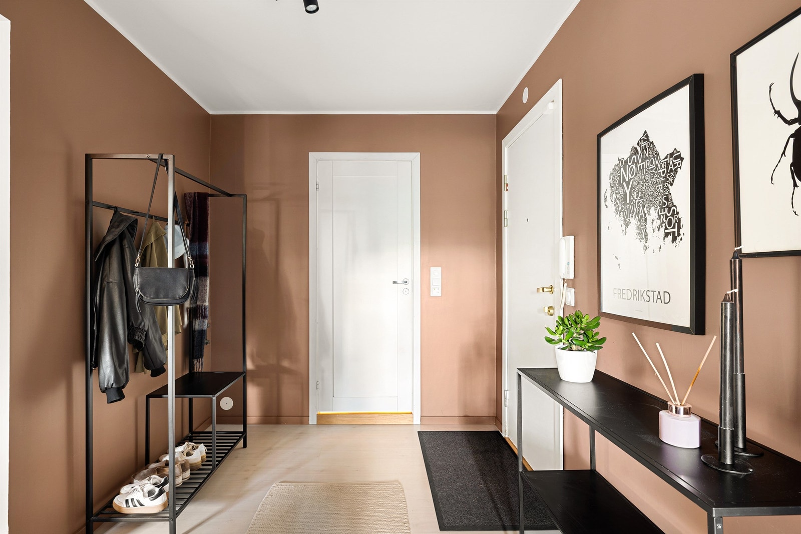 Entréen preges av varm fargesetting, og god lysføring som gir en innbydende adkomst til leiligheten. Galleribilde