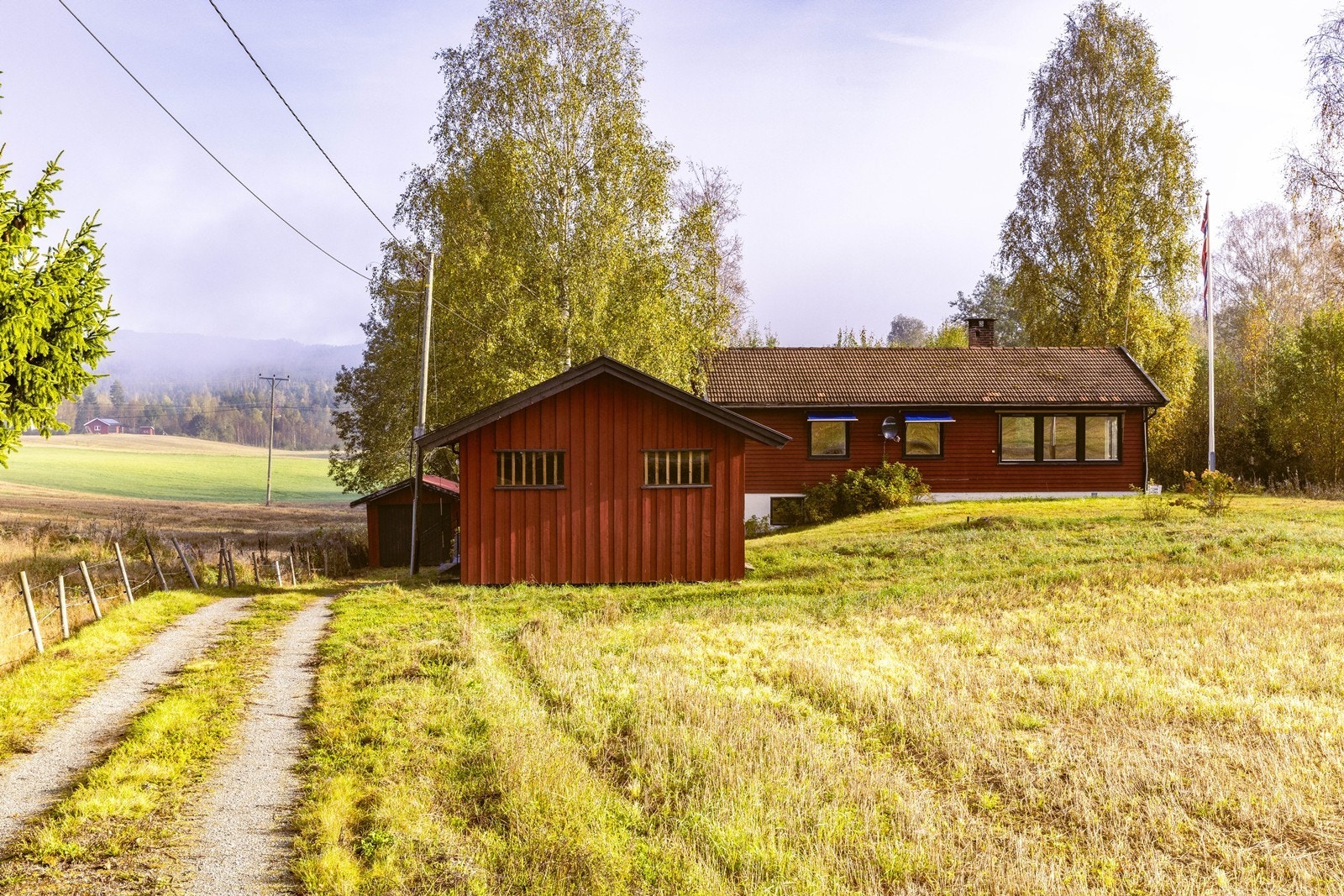 Tomten er opparbeidet med gressplen, gruset vei og gårdsplass. Galleribilde