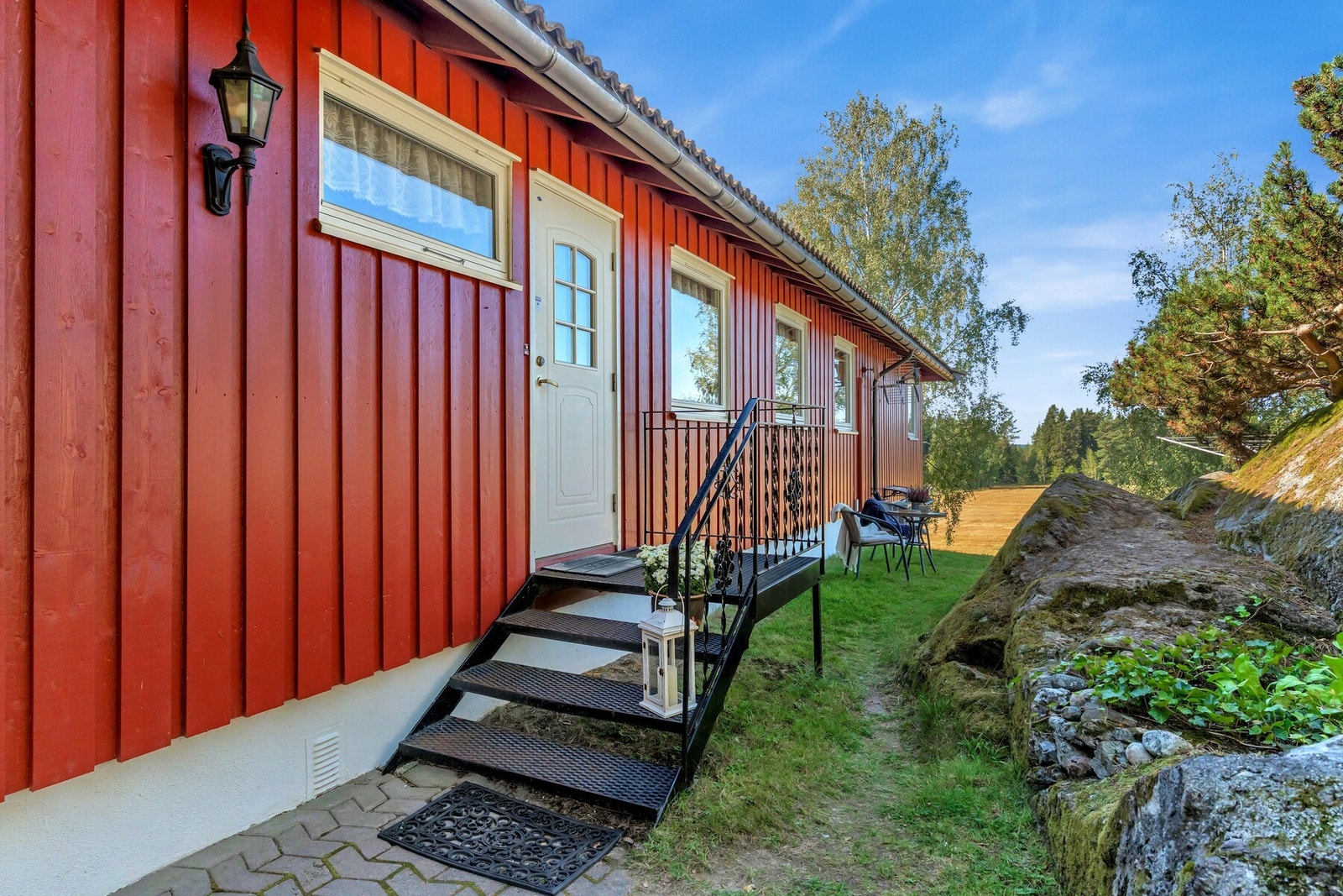 Inngangspartiet er pent opparbeidet med belegningsstein og smijern trapp. Galleribilde