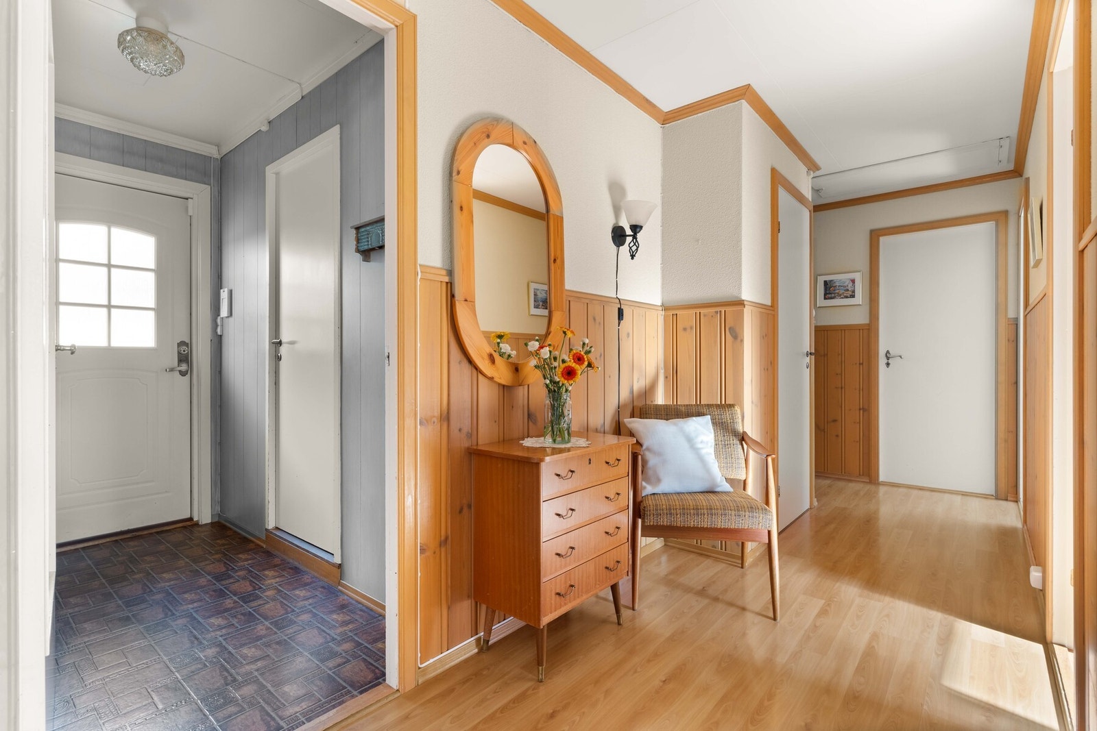 Lys og trivelig entré med praktisk gulvbelegg. Inne i gangen er det laminat på gulv. Galleribilde