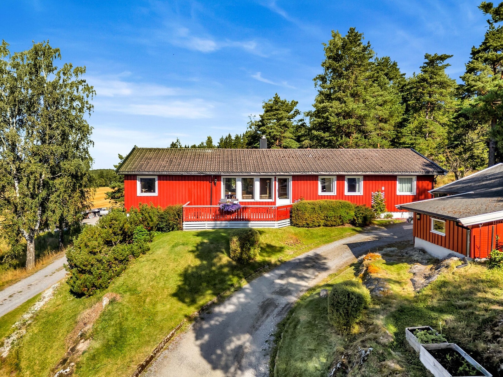 Tomten skråner lett og gir en følelse av naturlig romslighet, samtidig som de synlige fjellene mot nord og øst tilfører karakter og et særpreg til eiendommen. Galleribilde