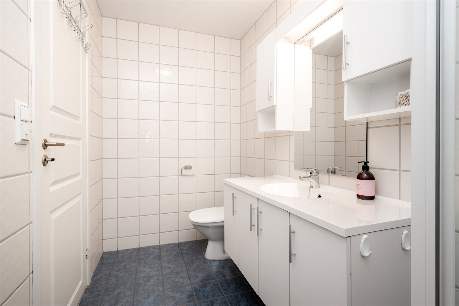 Pen, tidløs og bred servantinnredning med skap og heldekkende servantplate. Speil og praktiske sideskap på vegg, samt overlys med el-stikk. Galleribilde