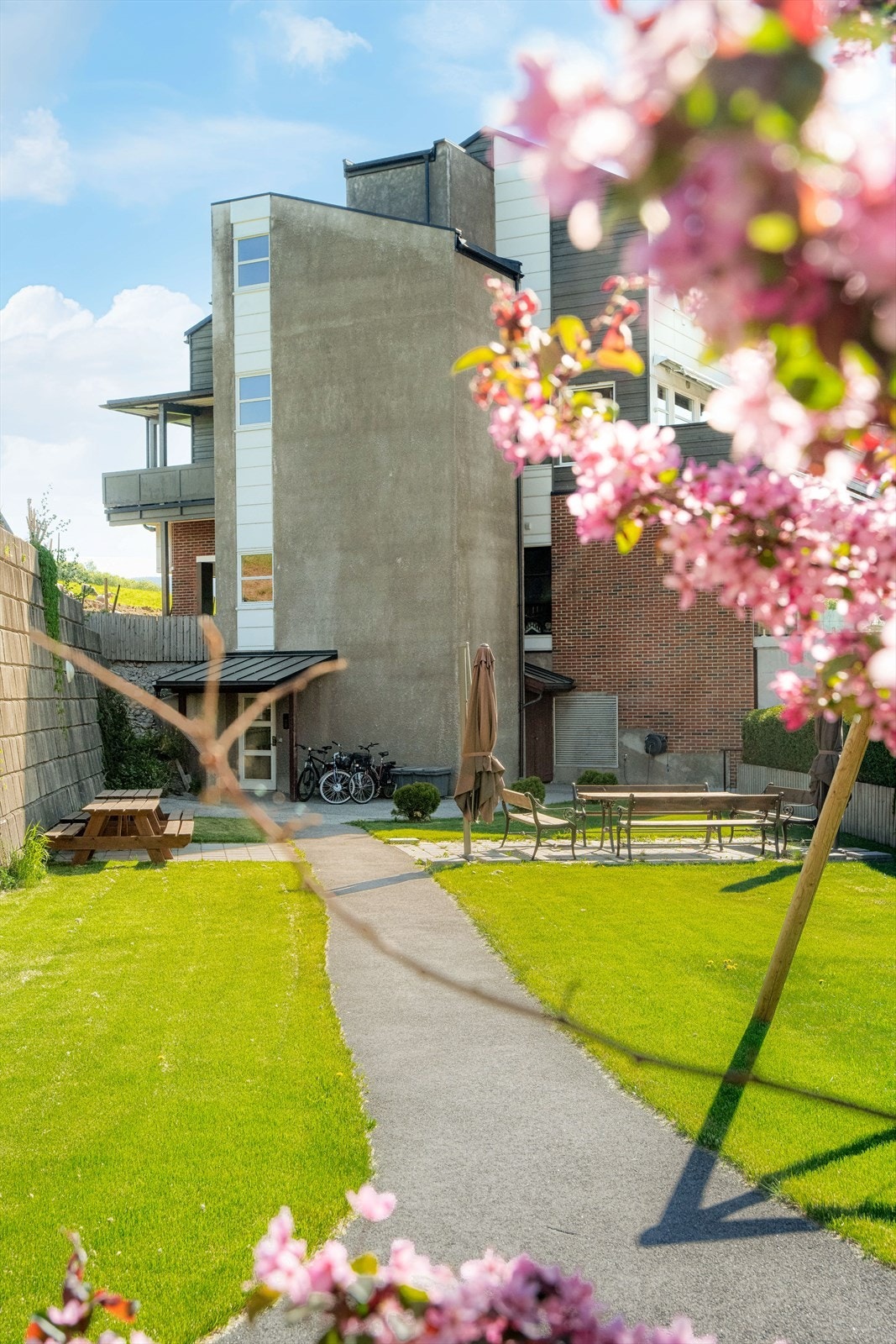 Borettslagets del av tomten er pent opparbeidet med felles, asfaltert parkeringsplass og internveier. Galleribilde