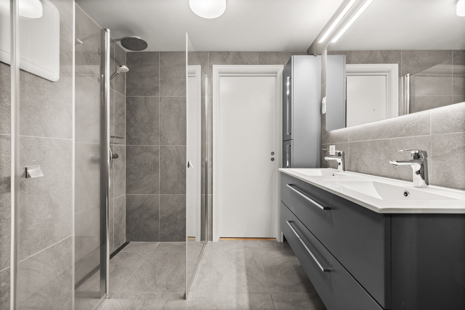 Badet inneholder både praktisk baderomsinnredning, dusjhjørne, toalett og vaskeromsløsning Galleribilde